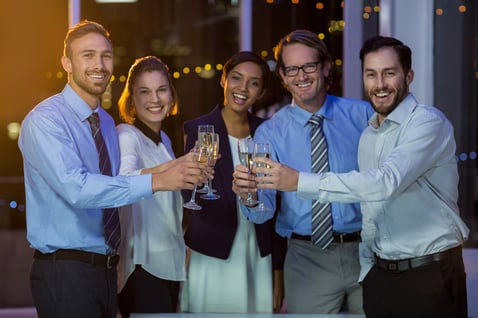 Portrait of businesspeople toasting glasses of champagne in office at night